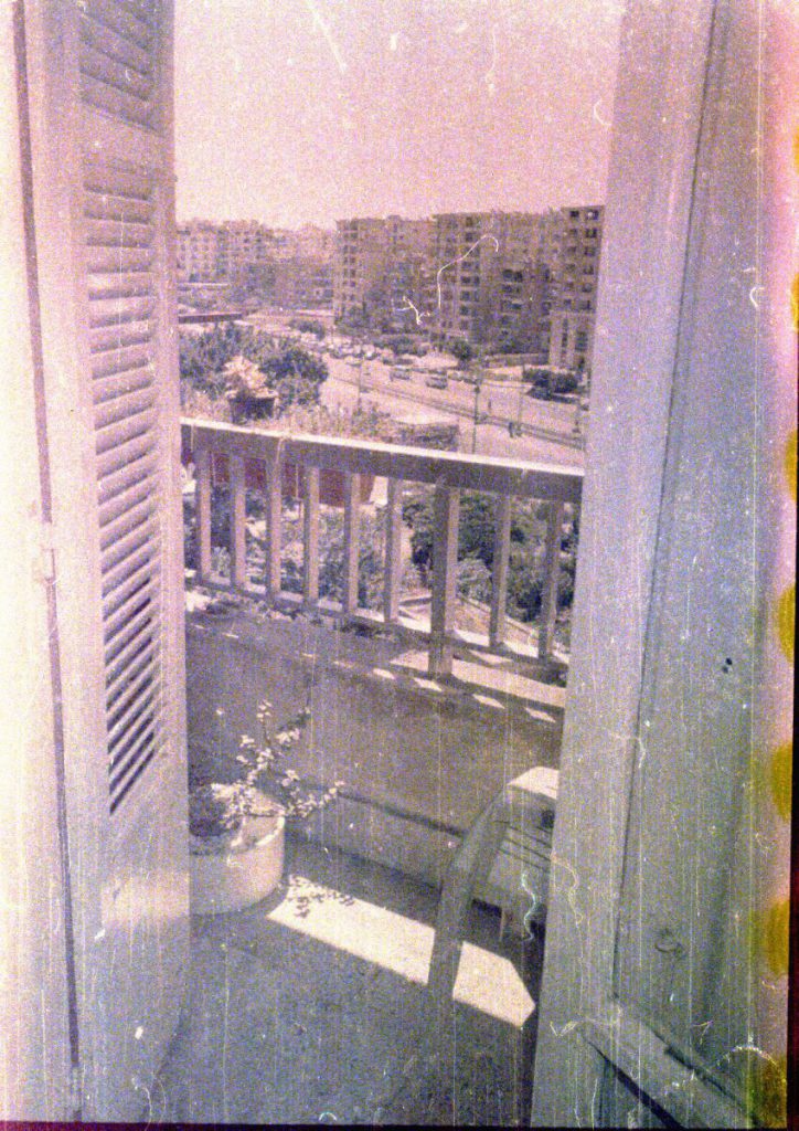 A view from my balcony onto the main street of my neighborhood in Cairo, when the tram still passed through it. Analogue photo from film roll shot in 2007 and developed in 2019, part of an ongoing photographic practice documenting everyday life.